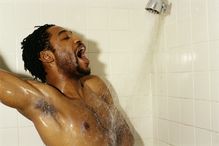 Young man singing in shower, eyes closed