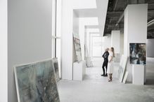 Art dealers examining paintings in a gallery.