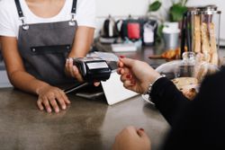 Customer using a credit card reader at a cafe