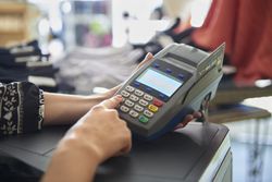 Woman using credit card terminal