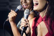 Friends singing karaoke in nightclub