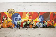 Volunteers painting a wall mural