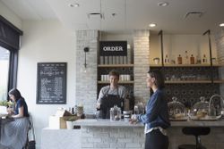 Woman ordering coffee at the counter of a store that just opened.