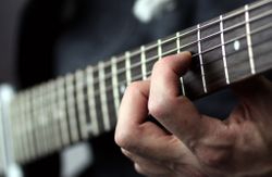 Fingers on a guitar fret