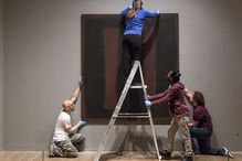 Art handlers hanging a Mark Rothko painting that has been restored.