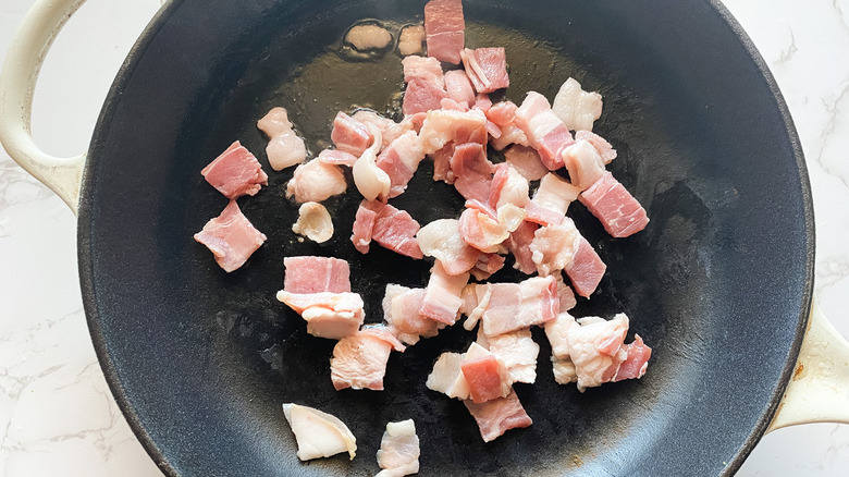 Sliced bacon placed in a skillet.