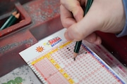 A person fills out a Mega Millions play slip ahead of Friday's Mega Millions drawing of $1.22 billion, Thursday, Dec. 26, 2024.