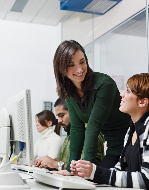 Woman assisting another woman on computer