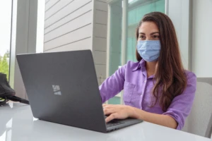 a person sitting at a table using a laptop computer