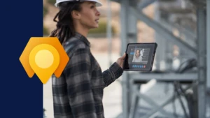 A field service employee wearing a hard hat, holding a tablet