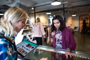 A women uses a surface tablet to help a female customer in a small SMB boutique retail shop