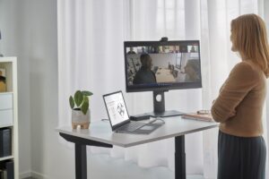 Surface Hub remote participant standing at a desk showing the Hub 2 Smart Camera perspective.