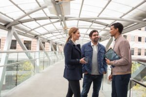 Business people on office skybridge with tablet and phone.