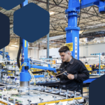 Photo of a worker using industrial tool in electronics factory assembly line.