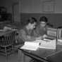 Black and white photograph of MISLS students Isami Osato and George Sakanari translating Japanese civil service regulations into English at Fort Snelling, c.1944.