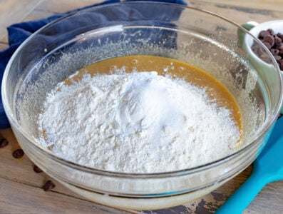 adding dry ingredients to wet ingredients in glass bowl