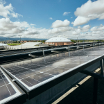 A view of rooftop solar panels with the MSU campus in the background