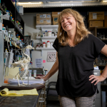 Dana Rashid standing next to a chicken skeletal model in a lab.