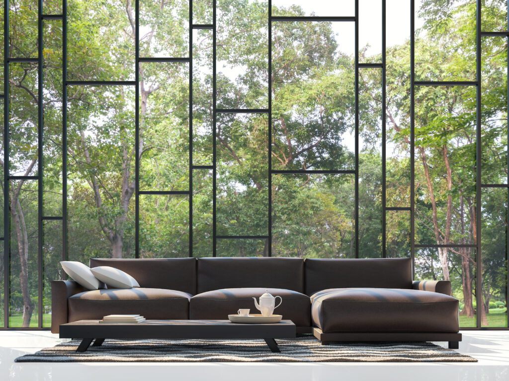 Modern living room with large floor-to-ceiling windows with view of nature