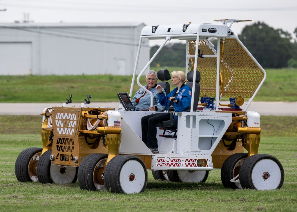 NASA astronaut Kate Rubins takes Apollo 17 Lunar Module Pilot Harrison “Jack” Schmitt on a ride on NASA’s rover prototype at Johnson Space Center in Houston.