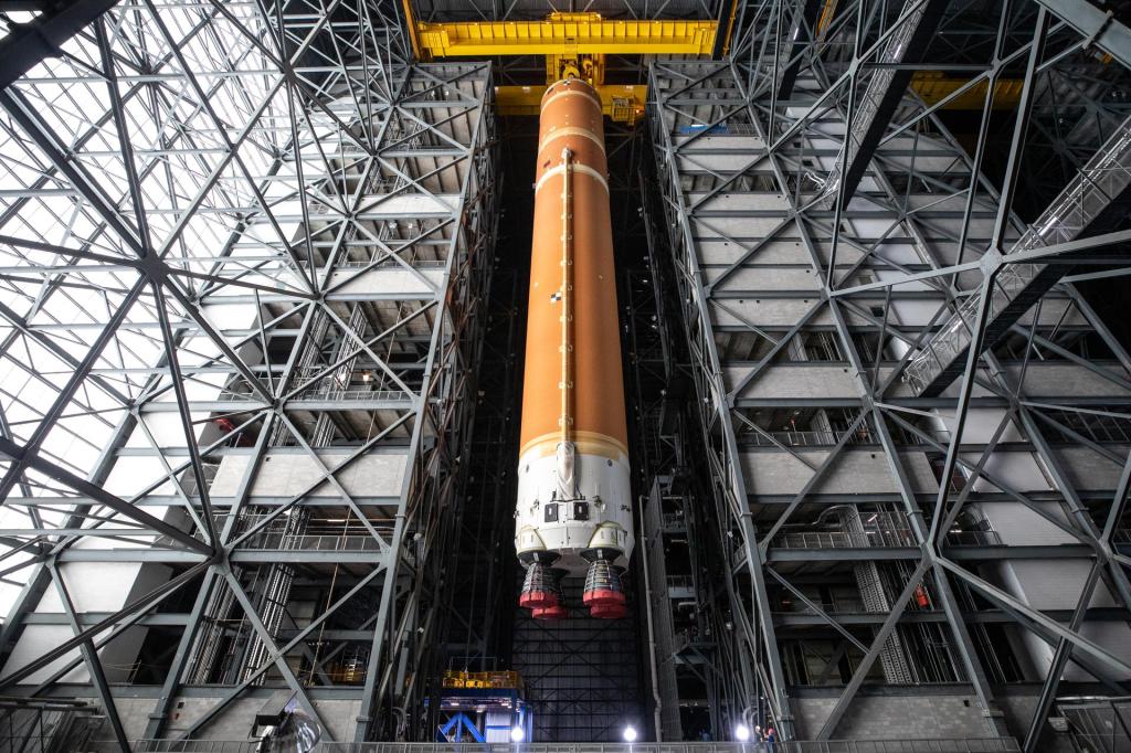 The fully assembled SLS (Space Launch System) core stage for the Artemis II test flight is suspended 225 feet in the air inside the newly renovated High Bay 2 at Kennedy’s Vehicle Assembly Building. The core stage was lifted to enable engineers to complete work before it is stacked on mobile launcher 1 with other rocket elements. With the move to High Bay 2, technicians now have 360-degree tip to tail access to the core stage, both internally and externally.