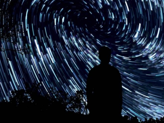 silhouette of a person in front of night sky full of stars - credit jeremy thomas, unsplash