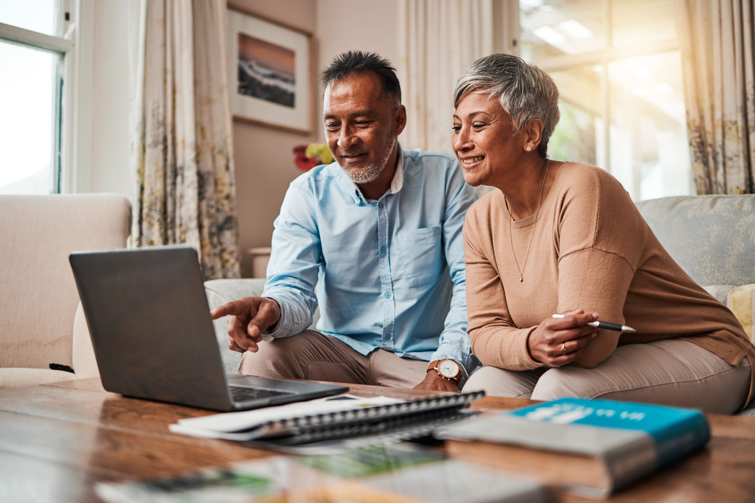 Mature couple, sofa and laptop for planning finance, retirement funding and investment or asset management at home. Elderly people or man and woman reading information on computer for pension savings