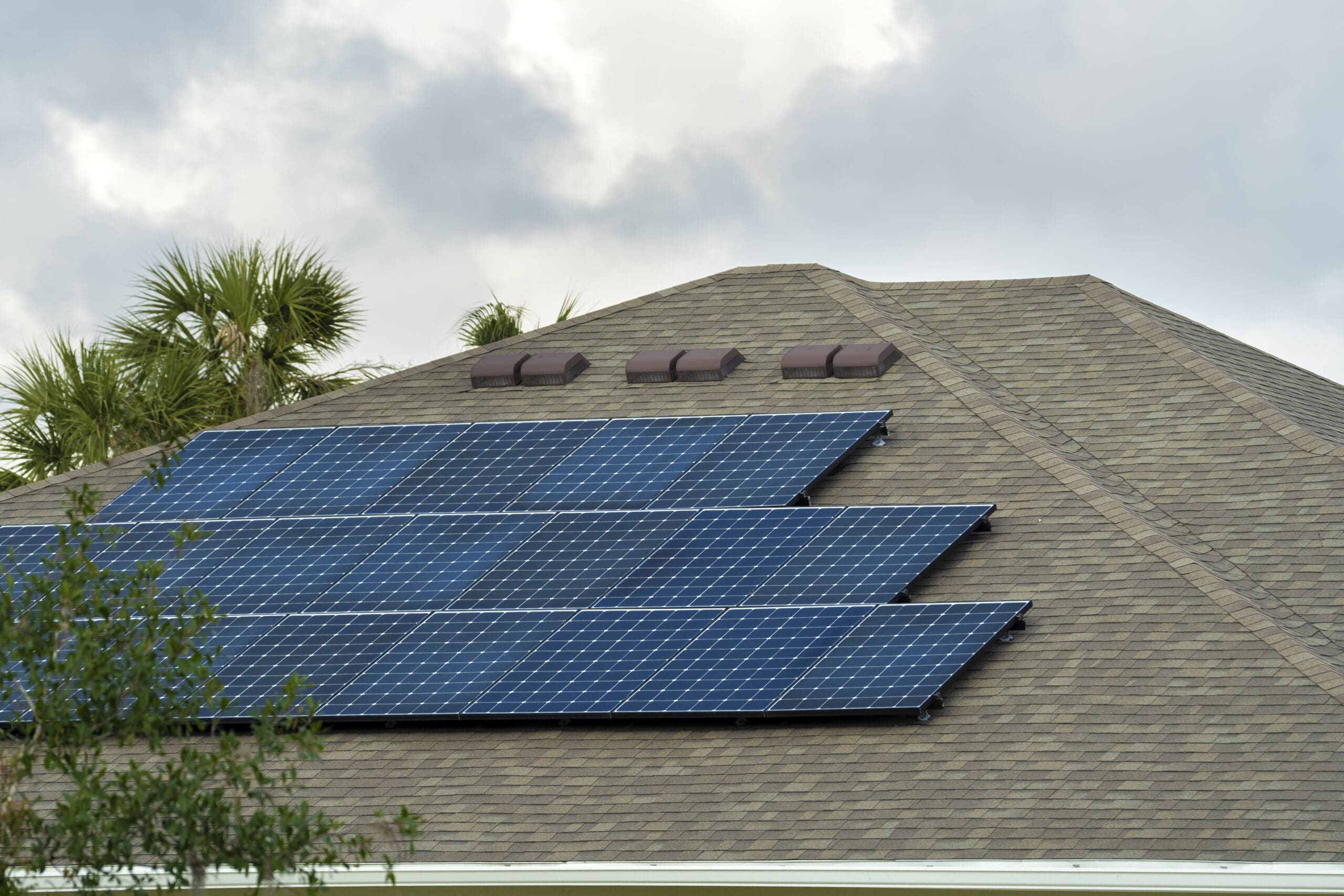 Residential house with rooftop covered with solar photovoltaic panels for producing of clean ecological electrical energy in suburban rural area. Concept of autonomous home.