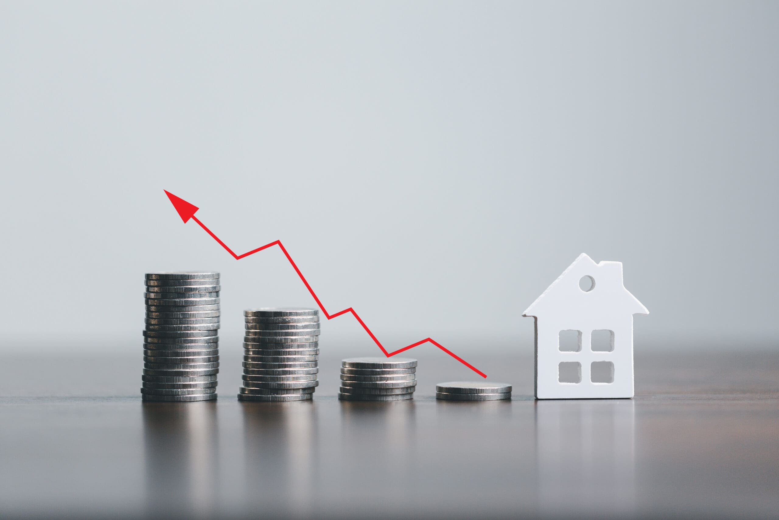 Real estate market, graph, up arrow. Mini house and a stack of coins.The concept of inflation, economic growth, the price of insurance services, growth saving money future for home.