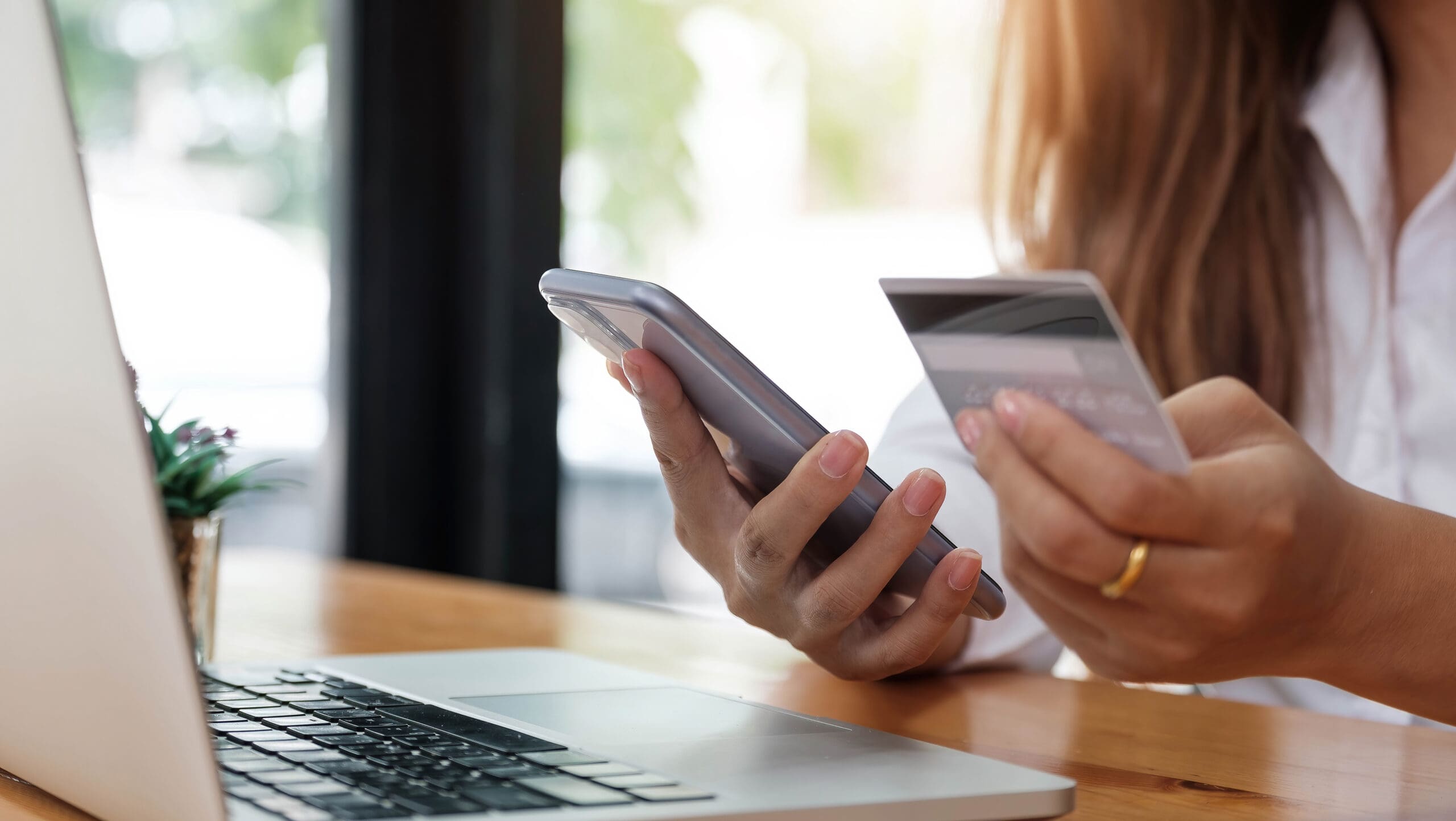 Online payment woman's hands holding smartphone and using credit card for online shopping. Cyber Monday Concept