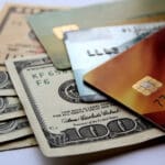 Stack of credit cards and american dollars, close-up view. Horizontal financial business background.