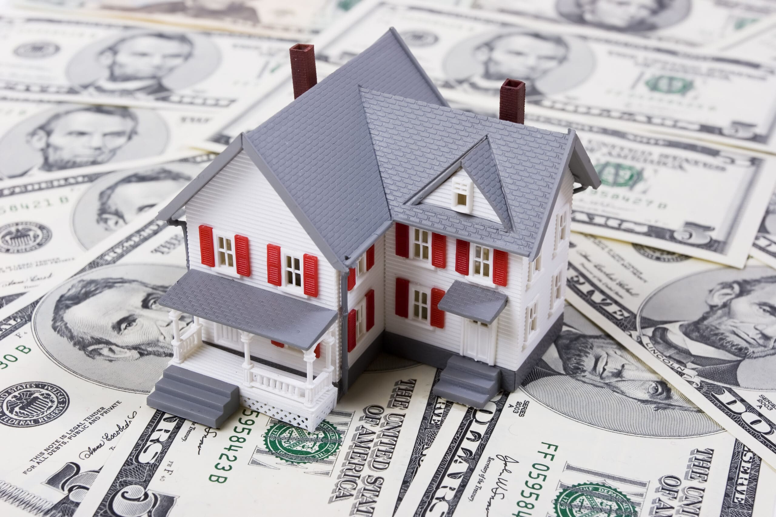 Two-story house with five dollar bills background