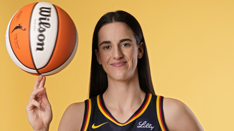 Caitlin Clark posing with a basketball