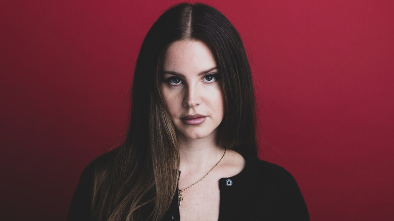 Lana Del Rey poses against red background