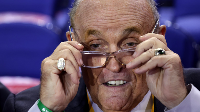 Rudy Giuliani putting on glasses