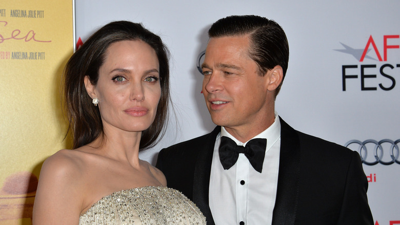 Angelina Jolie looking at camera and Brad Pitt looking at her