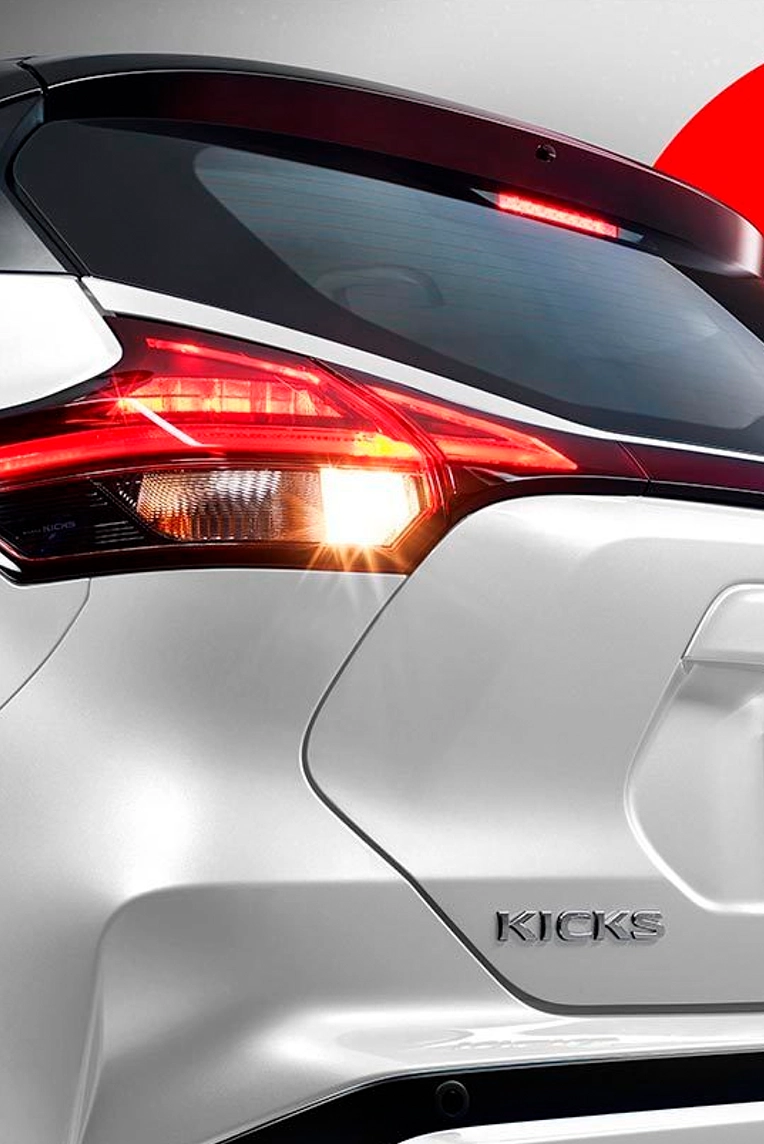 farol traseiro ligado de um Nissan Kicks branco.