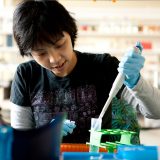 Image of graduate student working with a beaker in the Pfizer Lab.