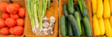 Green, yellow, and red vegetables piled into brown baskets