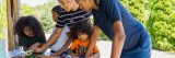 2 adults and 3 children making crafts in Everett Children's Adventure Garden