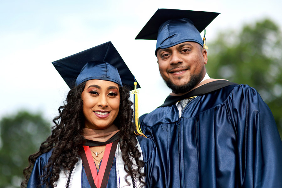 Two graduating students pictured at commencement. 