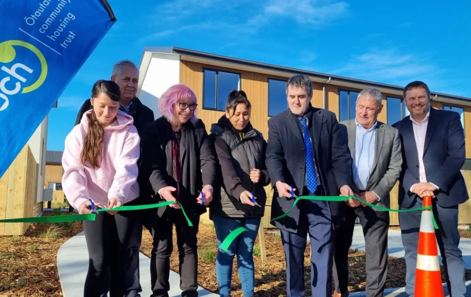 (From left) A Ngāi Tūāhuriri whānau member moving into one of the houses, with Barry Bragg, Cate...