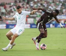 Kosta Barbarouses of New Zealand and Julian Quinones of Mexico vie for the ball in the first half...