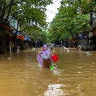 A woman wades through a flooded street following the impact of Typhoon Yagi, in Thai Nguyen City,...