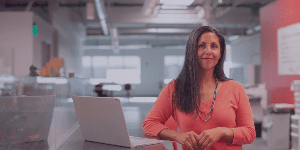 woman standing next to her laptop