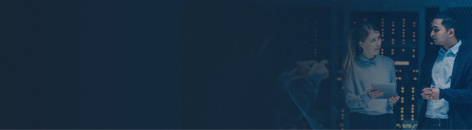 Dark blue banner with image of man talking to woman holding a tablet in hand in a server room.