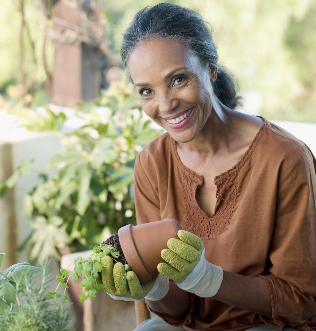 Patelco member Krystal repots a plant in her garden.