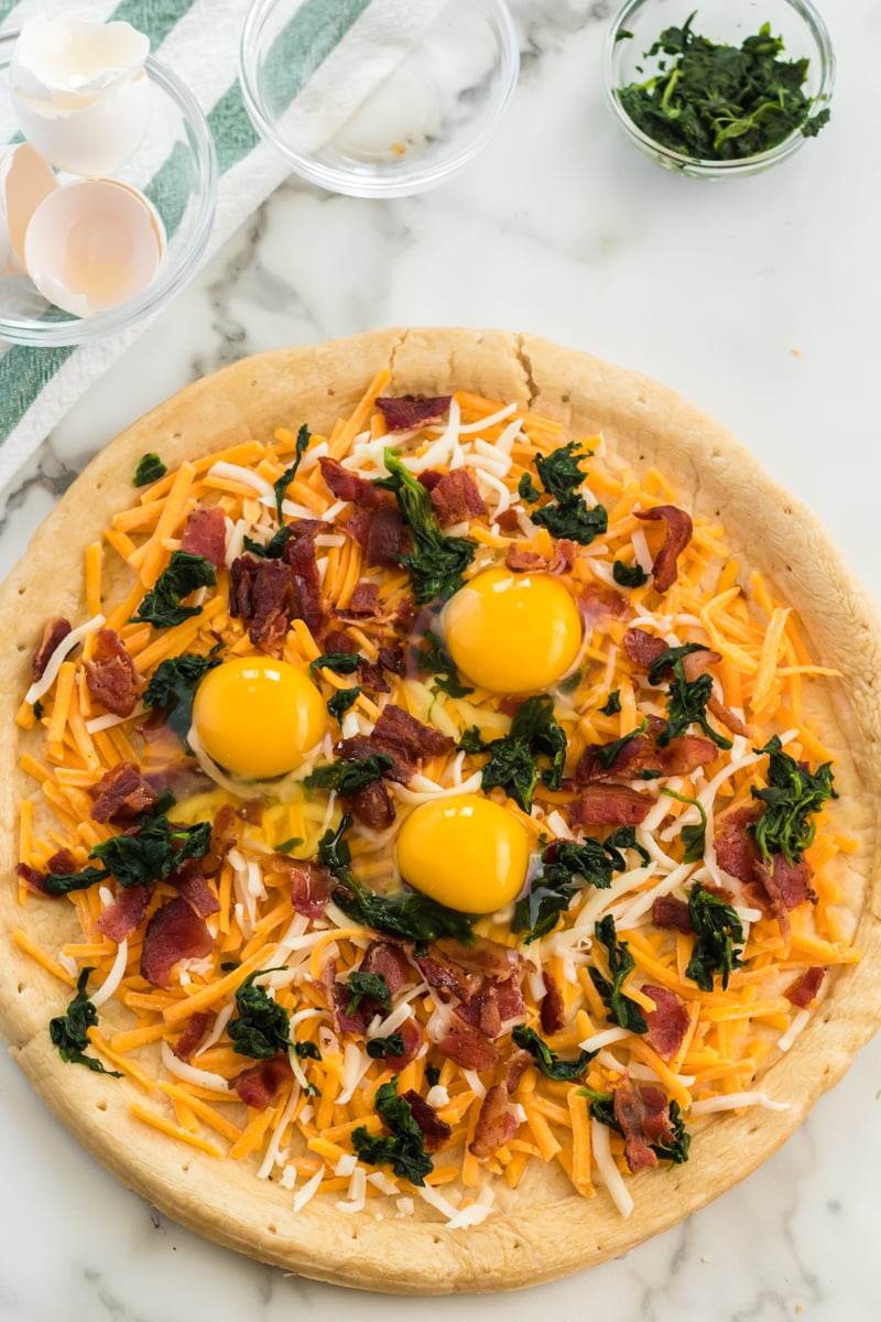 eggs cracked on breakfast pizza