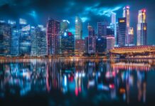 A city skyline at night with colorful reflections on the water, capturing the energy of an urban landscape.