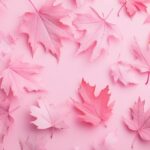 Soft pink autumn leaves scattered across a pale pink background.